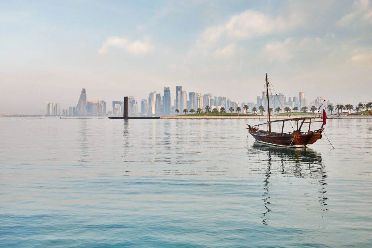 Beautiful city skyline view with a traditional boat on calm waters, showcasing urban and coastal att.